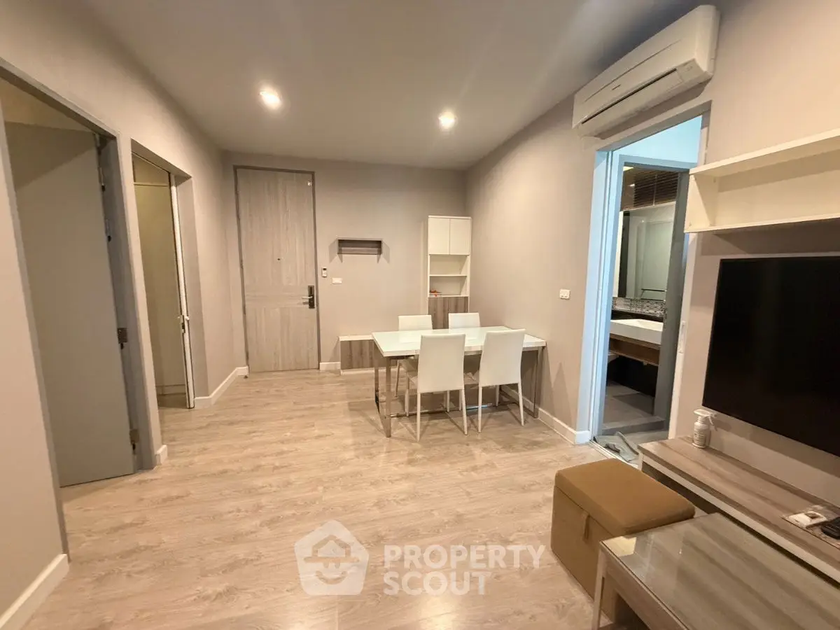 Modern living room with dining area and air conditioning in a stylish apartment.