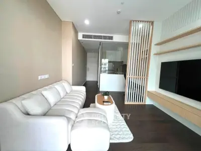 Modern living room with sleek design, featuring a cozy white sofa and wall-mounted TV.