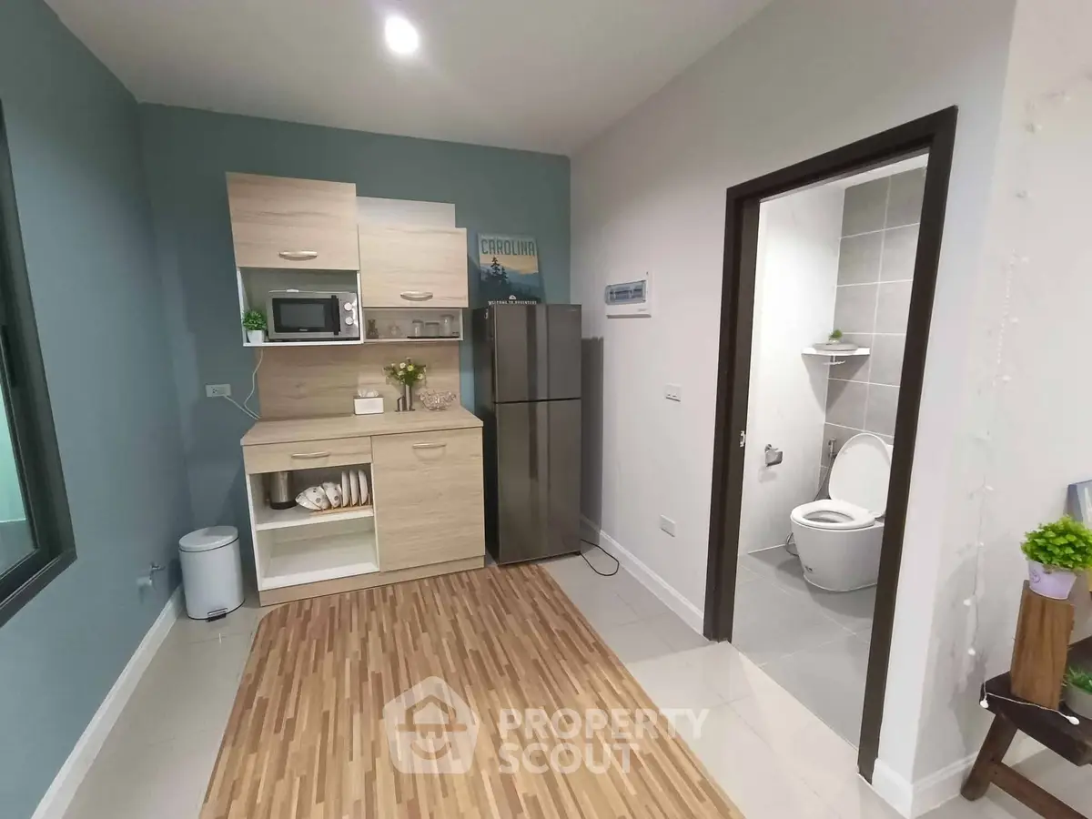 Modern compact kitchen with adjacent bathroom in a stylish apartment