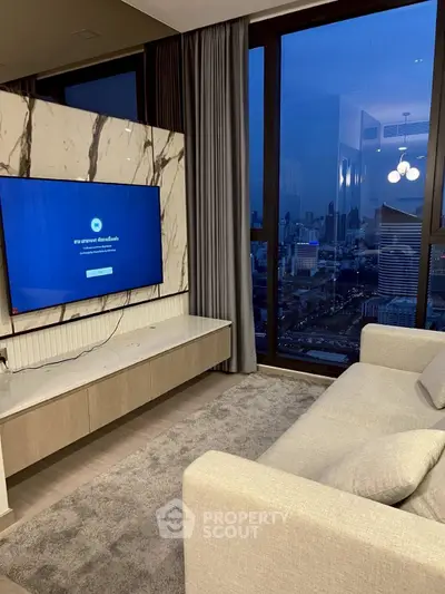 Modern living room with city view, featuring a large TV and elegant decor.