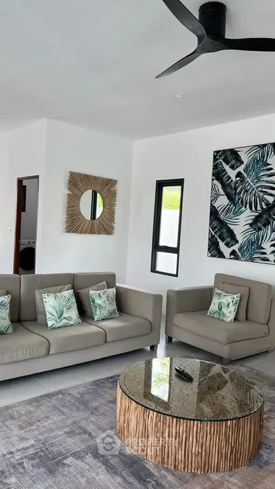 Stylish living room with modern decor and tropical accents, featuring a cozy sofa and chic coffee table.