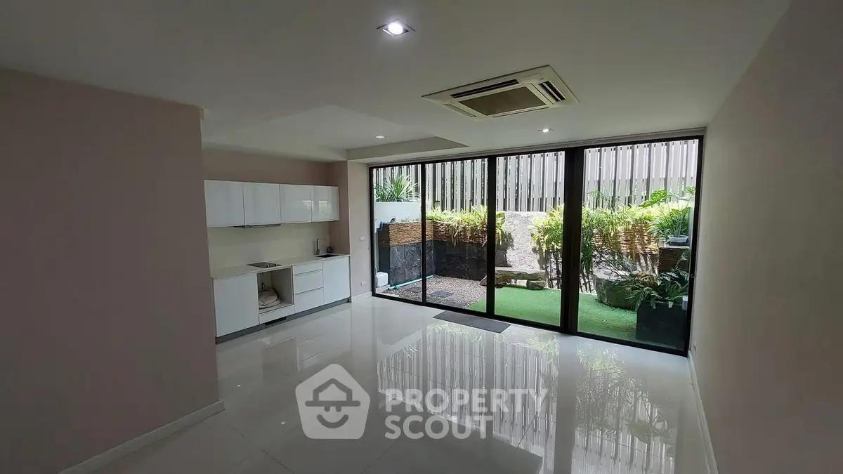 Spacious modern living room with garden view and sleek kitchen