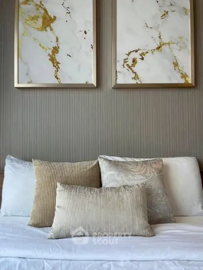 Elegant bedroom with stylish pillows and marble artwork, creating a luxurious and serene ambiance.
