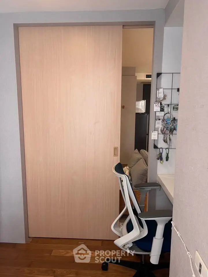 Modern study area with ergonomic chair and sliding door in a cozy apartment.