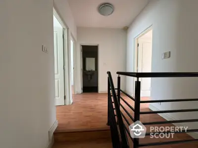 Spacious hallway with modern railing and wooden flooring