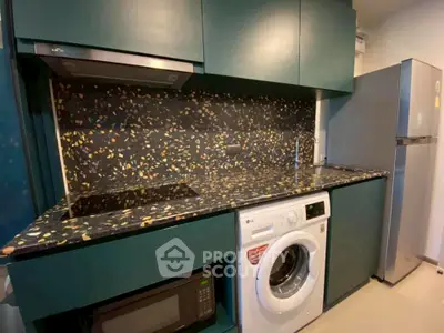 Modern kitchen with terrazzo backsplash, washing machine, and sleek appliances.