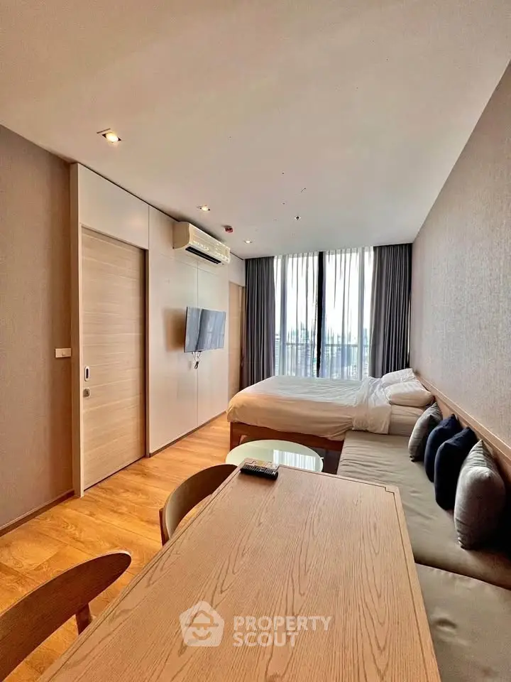 Modern studio apartment with wooden flooring and natural light