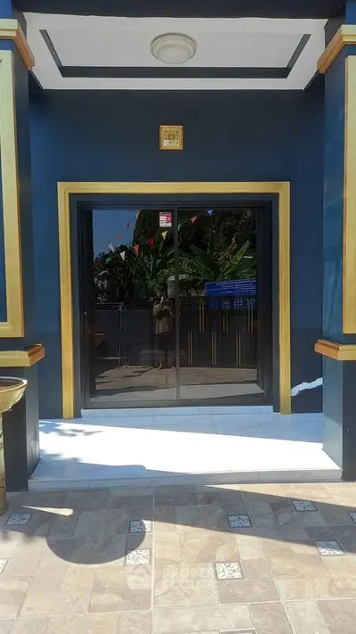 Elegant building entrance with modern glass doors and gold accents