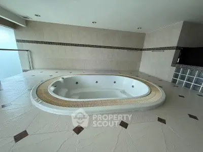 Luxurious indoor jacuzzi in a modern spa setting with elegant tile flooring.