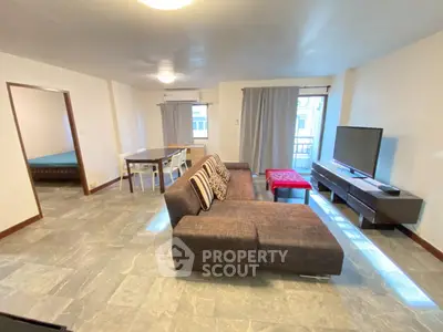 Spacious living room with modern furniture and natural light in a stylish apartment.
