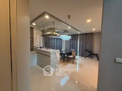 Luxurious modern dining area with elegant chandelier and marble island in open layout apartment.