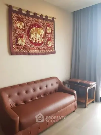 Cozy living room with elegant brown leather sofa and elephant tapestry wall art.