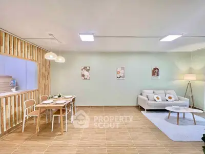 Spacious living room with modern decor and dining area, featuring elegant lighting and cozy seating.