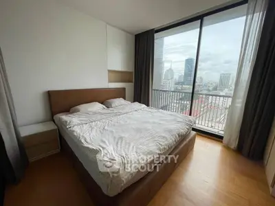 Modern bedroom with city view and large windows in high-rise apartment