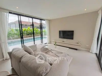 Luxurious living room with pool view and modern decor in a contemporary home.