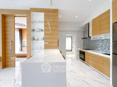 Modern kitchen with sleek design, marble flooring, and wooden cabinetry, featuring an open layout and built-in appliances.