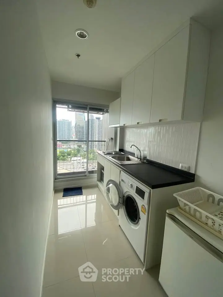 Modern laundry room with city view, featuring washing machine and sleek cabinetry.