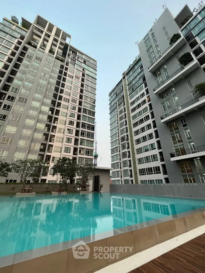 Modern high-rise apartment buildings with a luxurious swimming pool in the foreground.