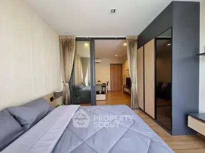 Modern bedroom with stylish decor and sliding glass doors leading to a cozy living area.