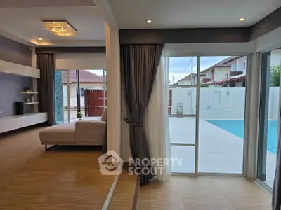 Spacious living room with pool view, modern design and elegant lighting