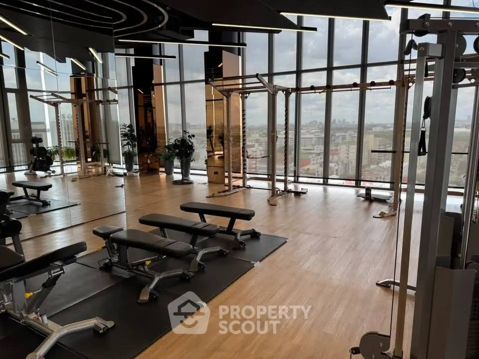 Luxurious high-rise gym with panoramic city views and modern fitness equipment.