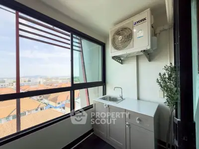 Charming balcony with sink and air conditioning unit overlooking scenic city view.