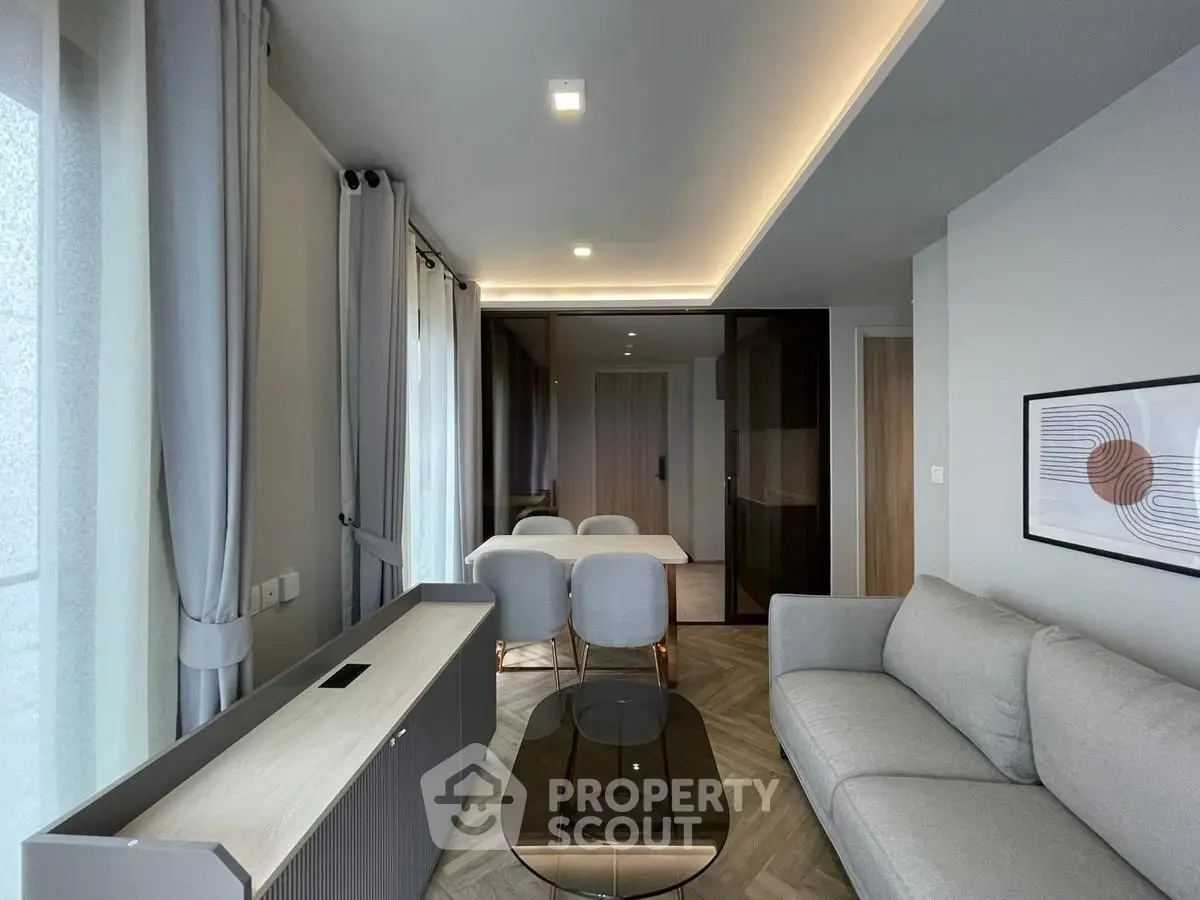 Modern living room with elegant decor and dining area, featuring sleek furniture and ambient lighting.