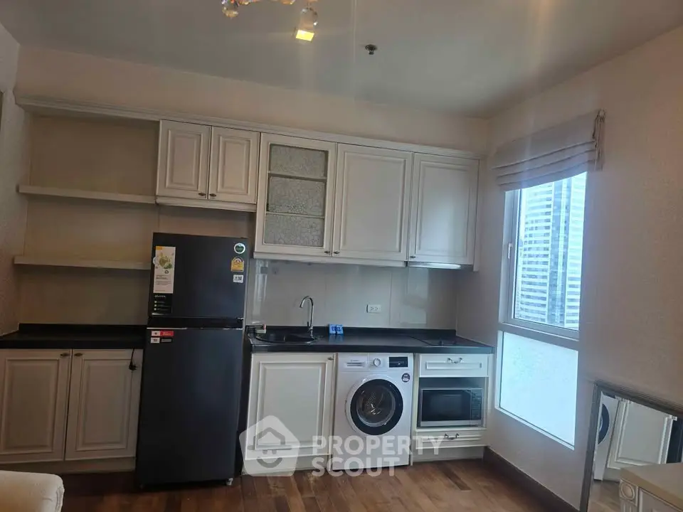 Modern kitchen with appliances including fridge, washing machine, and oven in a stylish apartment.