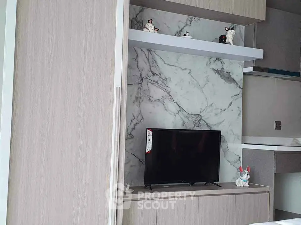 Modern living room with stylish marble accent wall and sleek TV setup