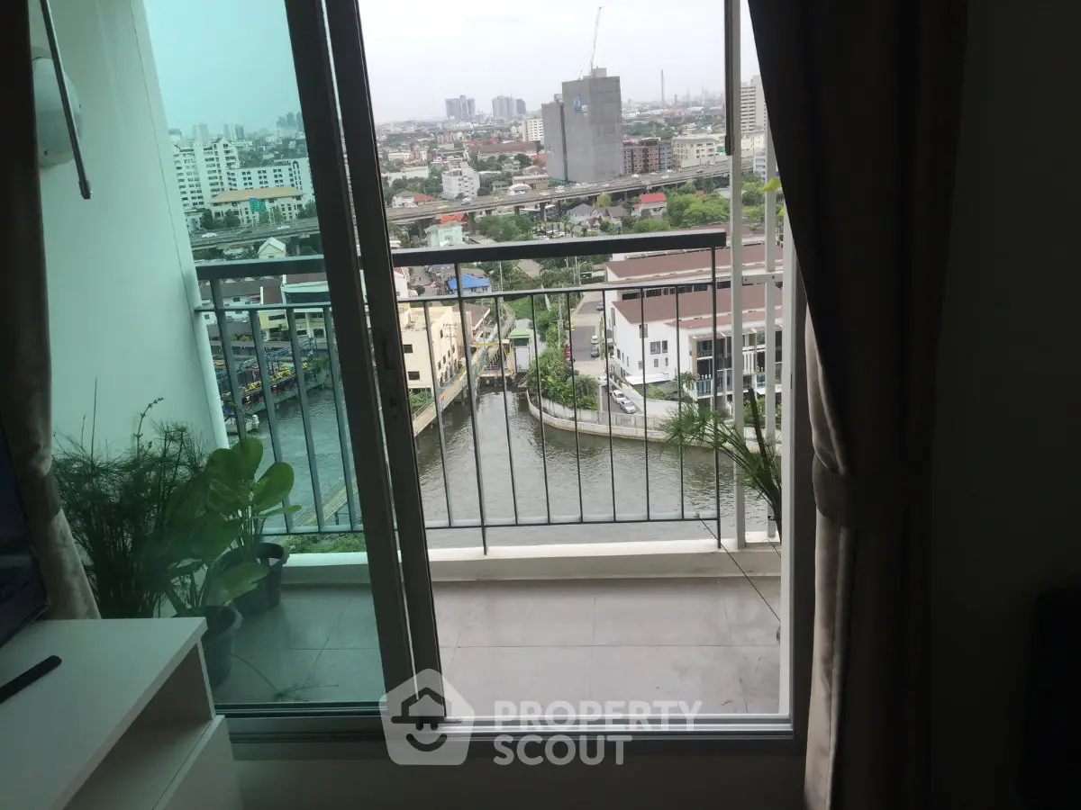 Stunning city view from a high-rise balcony overlooking a river, perfect for urban living.
