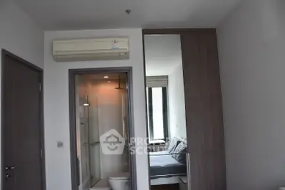 Modern apartment with compact bedroom and ensuite bathroom featuring sleek design and air conditioning.