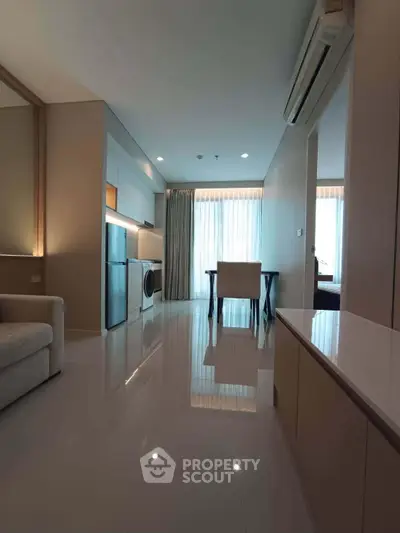 Modern apartment interior with sleek design, featuring open layout, washing machine, and dining area.