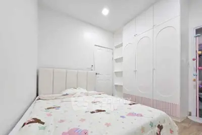 Cozy bedroom with modern white wardrobe and soft lighting, perfect for restful nights.