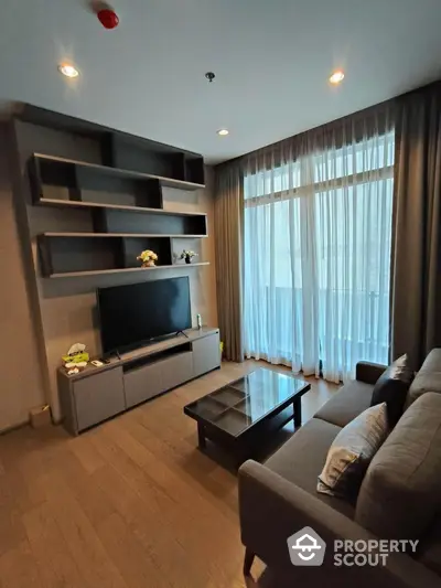 Modern living room with sleek furniture and large window for natural light.