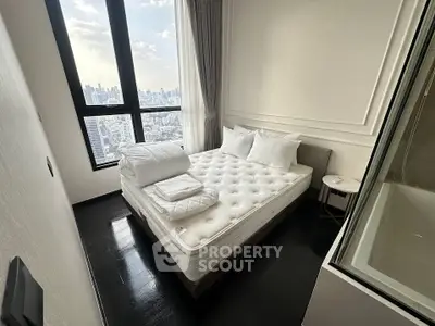 Luxurious bedroom with city view, featuring elegant decor and plush bedding in a high-rise apartment.