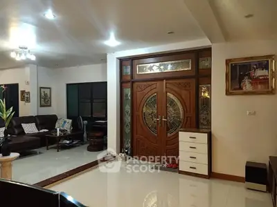 Spacious living room with elegant wooden door and modern decor