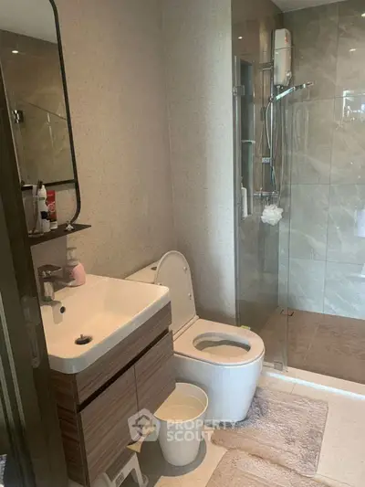 Modern bathroom with sleek fixtures and glass shower enclosure.