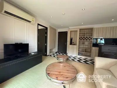 Modern living room with stylish decor and open layout, featuring a TV and air conditioning.