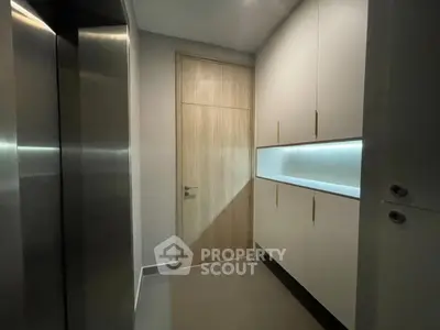 Modern apartment entrance with sleek elevator and stylish cabinetry