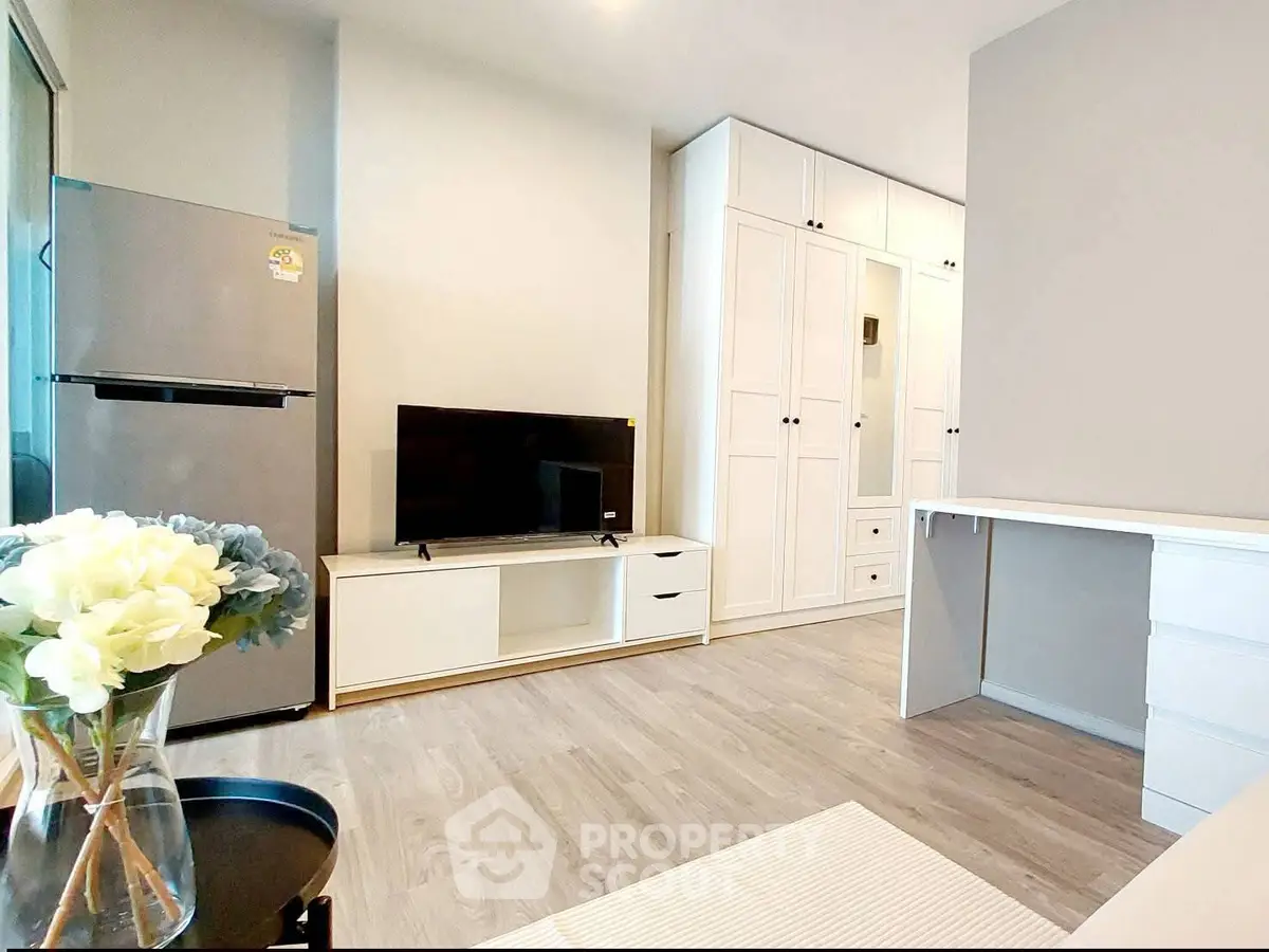 Modern living room with sleek design, featuring a TV, refrigerator, and elegant storage solutions.