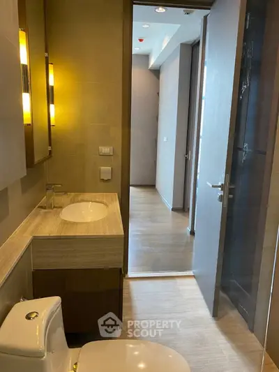 Modern bathroom with sleek fixtures and wooden accents in a contemporary apartment