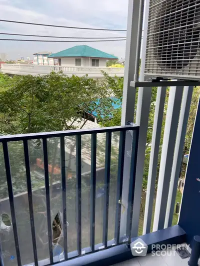 Charming balcony view with lush greenery and cityscape in the background