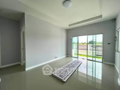 Spacious living room with large sliding doors leading to a balcony with scenic views.