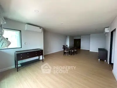 Spacious modern living room with wooden flooring and elegant dining set