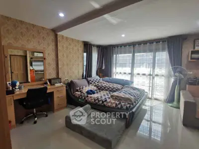 Spacious bedroom with modern decor and large windows for natural light.