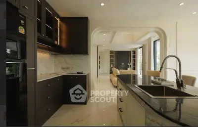 Luxurious open-layout kitchen with marble countertops and modern appliances, leading to a spacious living area.