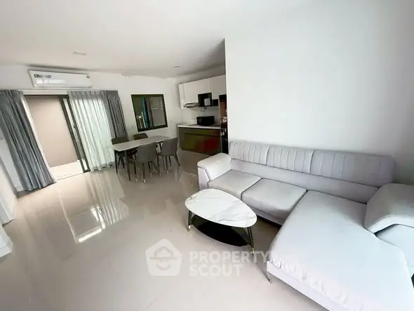 Spacious modern living room with sleek furniture and open kitchen layout