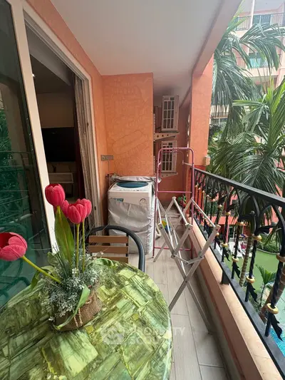 Charming balcony with lush greenery and cozy seating area, perfect for relaxation.