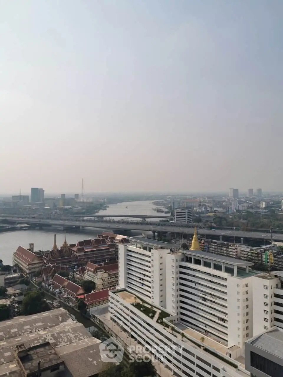 Stunning cityscape view from high-rise building overlooking river and urban skyline.