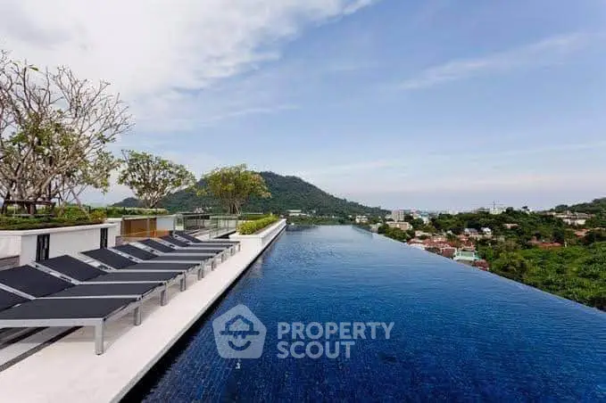 Luxurious rooftop infinity pool with stunning panoramic views of lush green hills and cityscape.